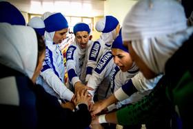 حلقه‌ی اتحاد دختران ملوانی قبل از شروع بازی در رختکن.